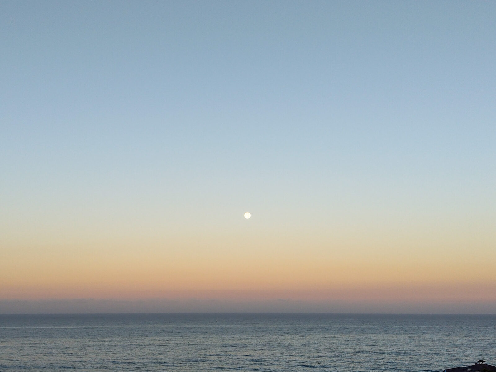 満月が浮かぶ早朝の海